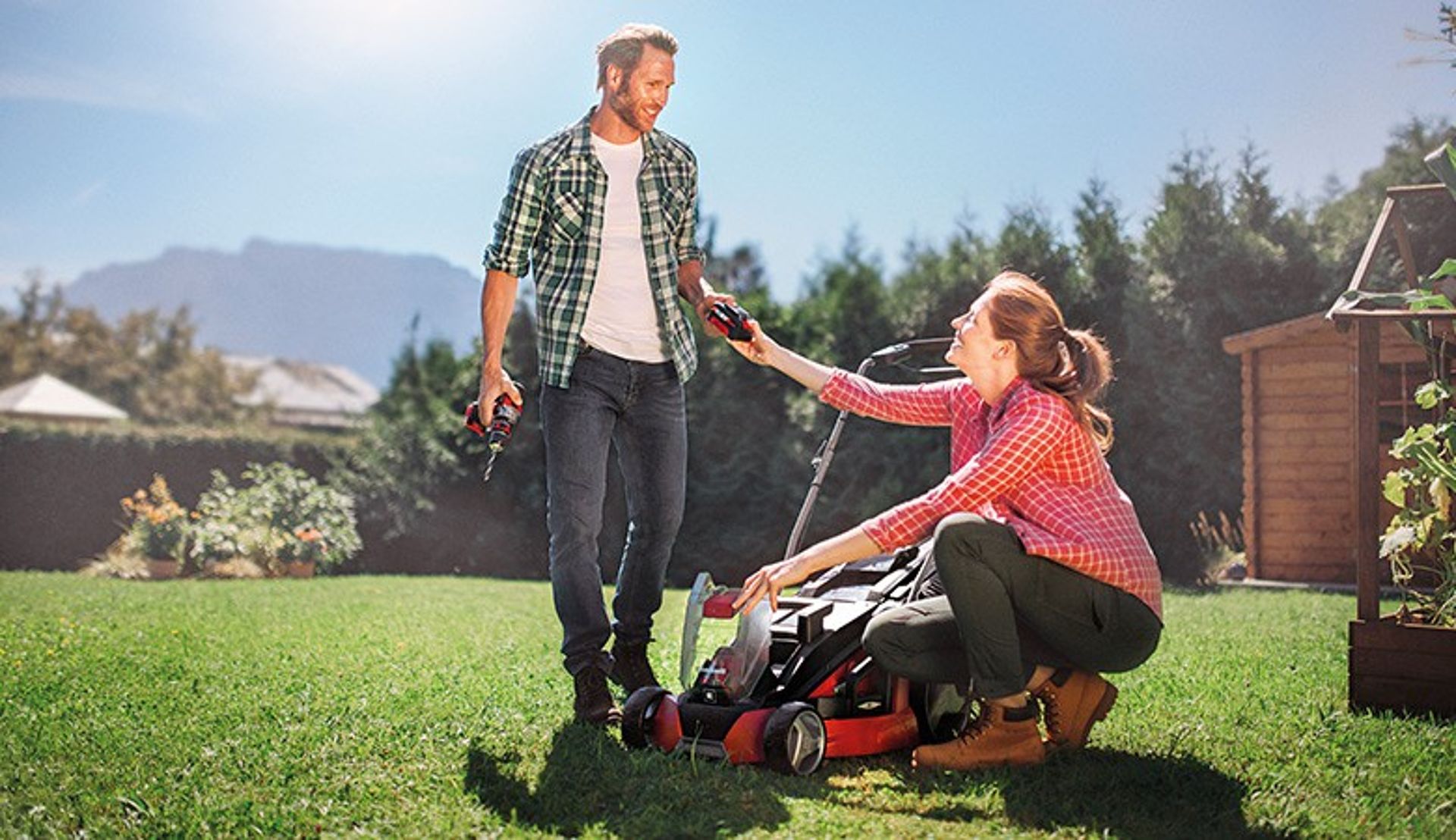 woman and man with einhell devices in a garden